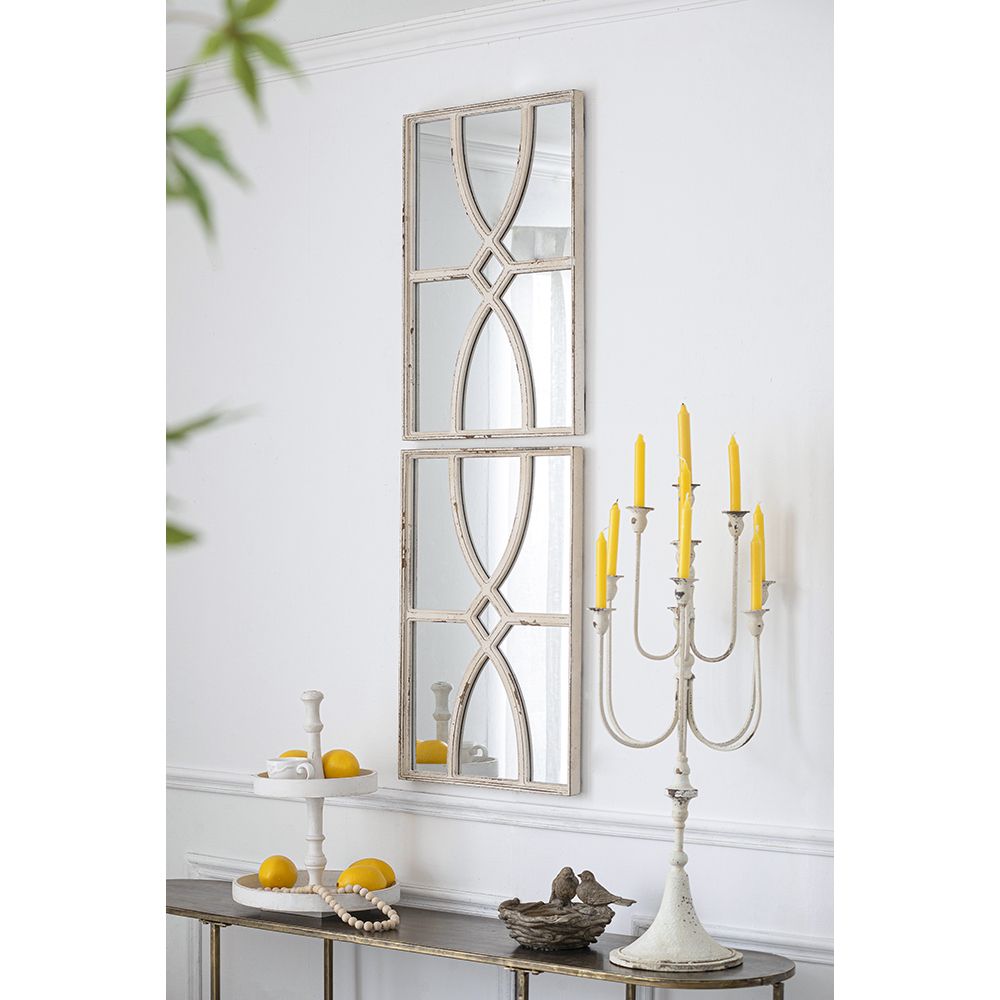 Set of two rectangular wooden wall mirrors with distressed white frame on a living room wall