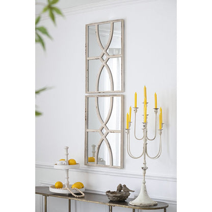 Set of two rectangular wooden wall mirrors with distressed white frame on a living room wall