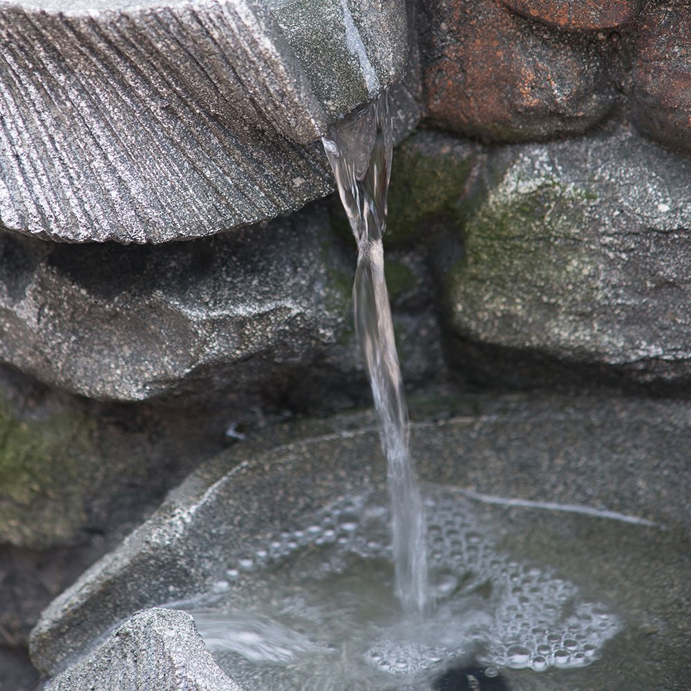 4-tier polyresin cascading rock water fountain with LED light - in garden setting