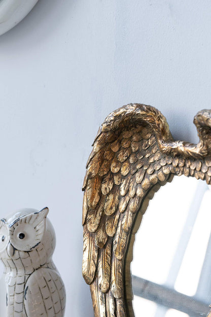 Golden wing mirror in foyer with decorative elements