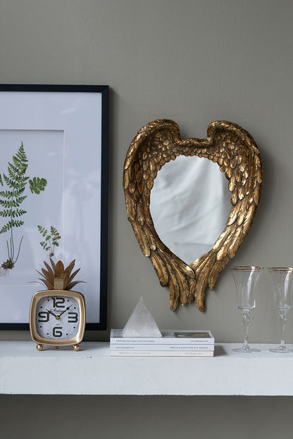 Golden wing mirror in entryway setting