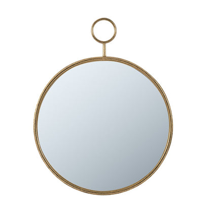 Gold round accent mirror on wall in entryway setting
