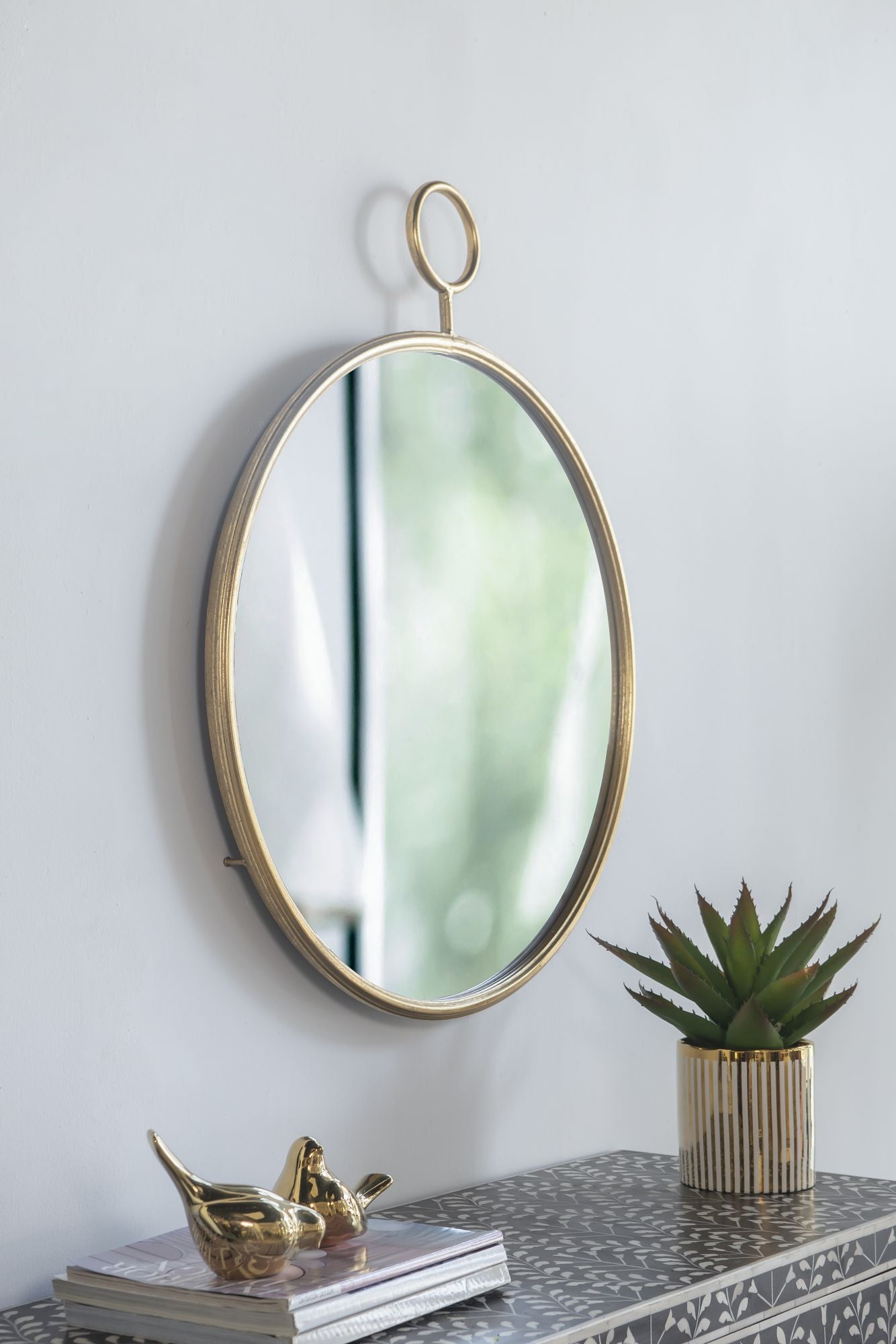 Gold framed mirror hanging above console table