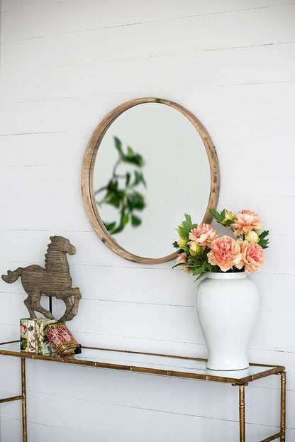 Round wood mirror mounted on wall in living room setting