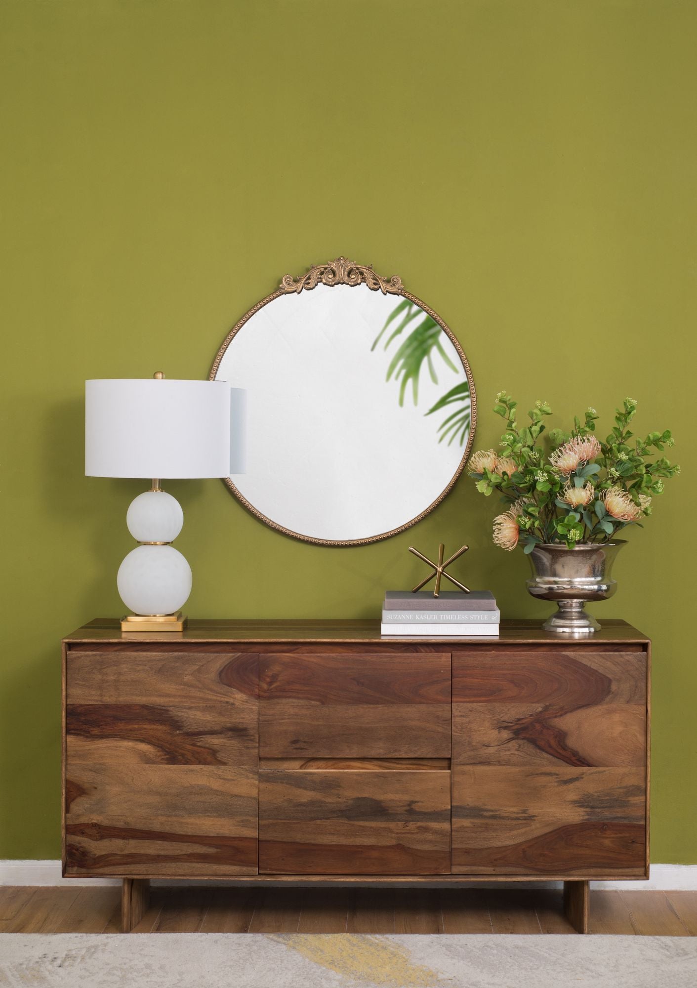 Round gold mirror hanging on wall in living room