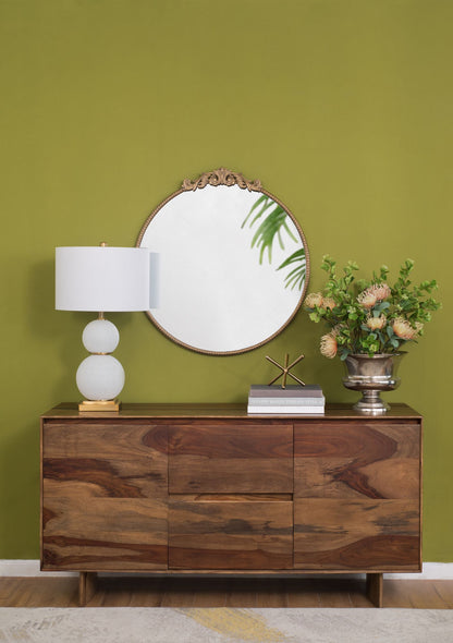 Round gold mirror hanging on wall in living room