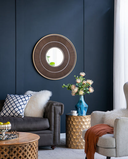 Close-up of gold iron frame and wooden border on round mirror