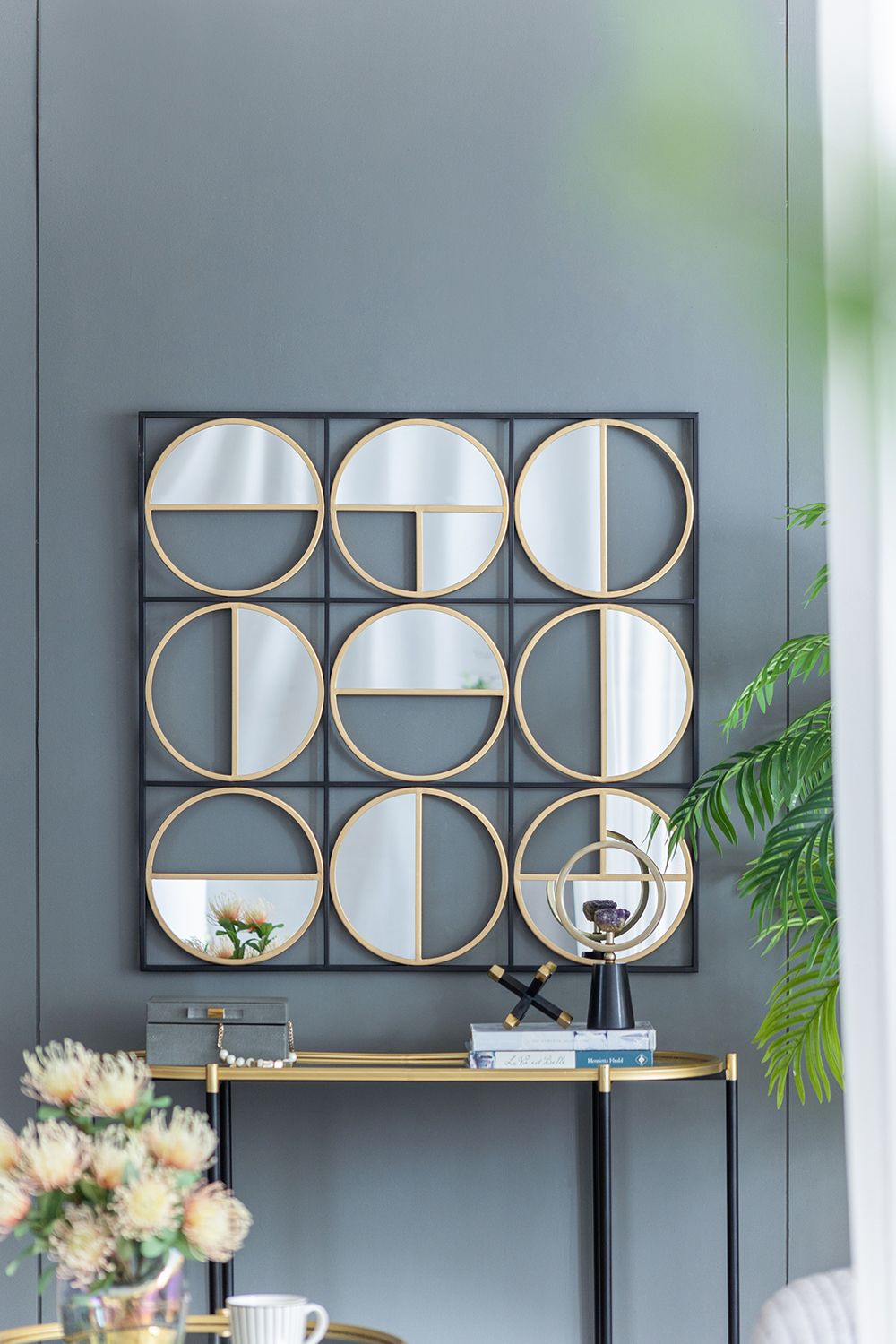 Black metal beaded mirror above console table