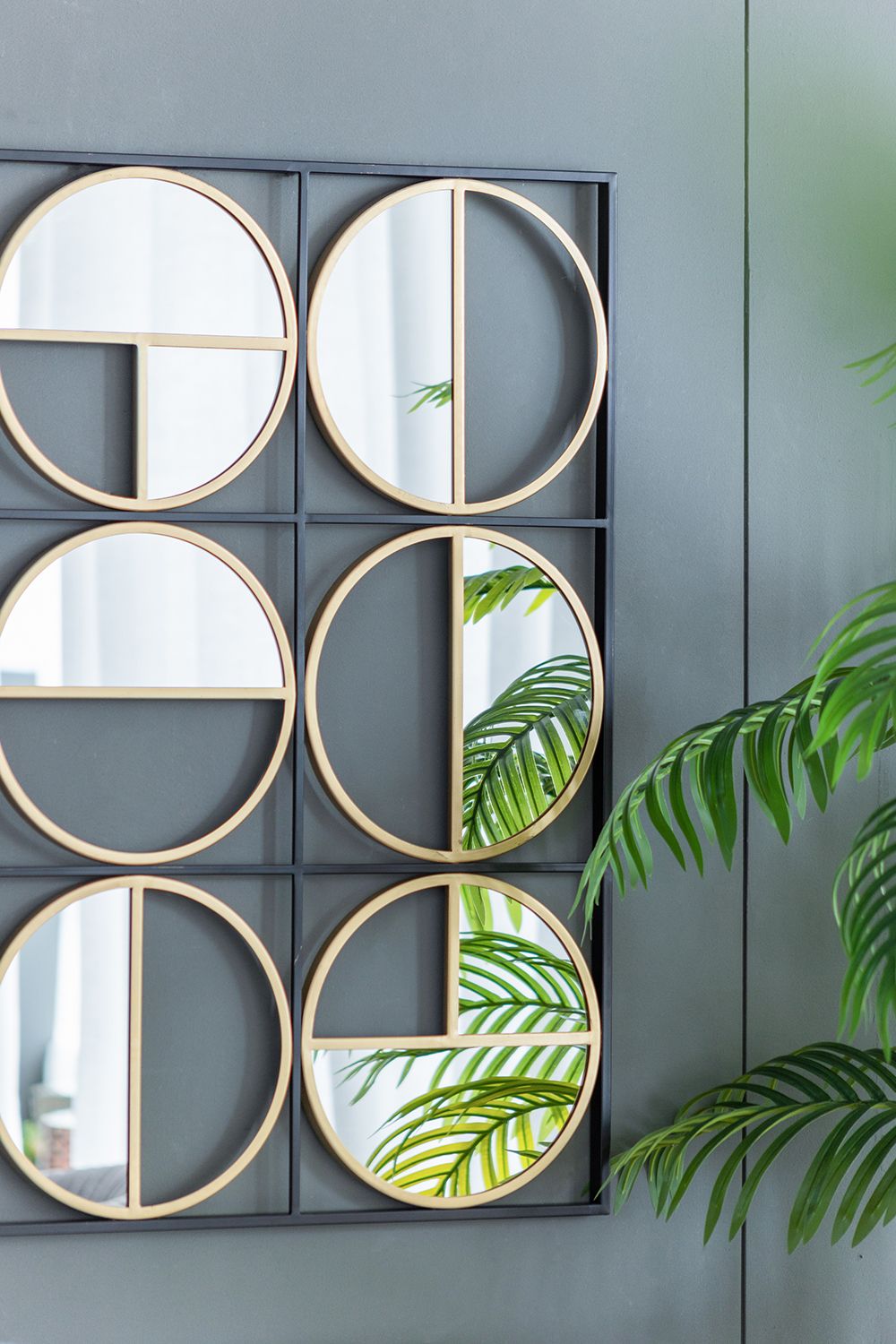 Metal beaded mirror hanging on wall