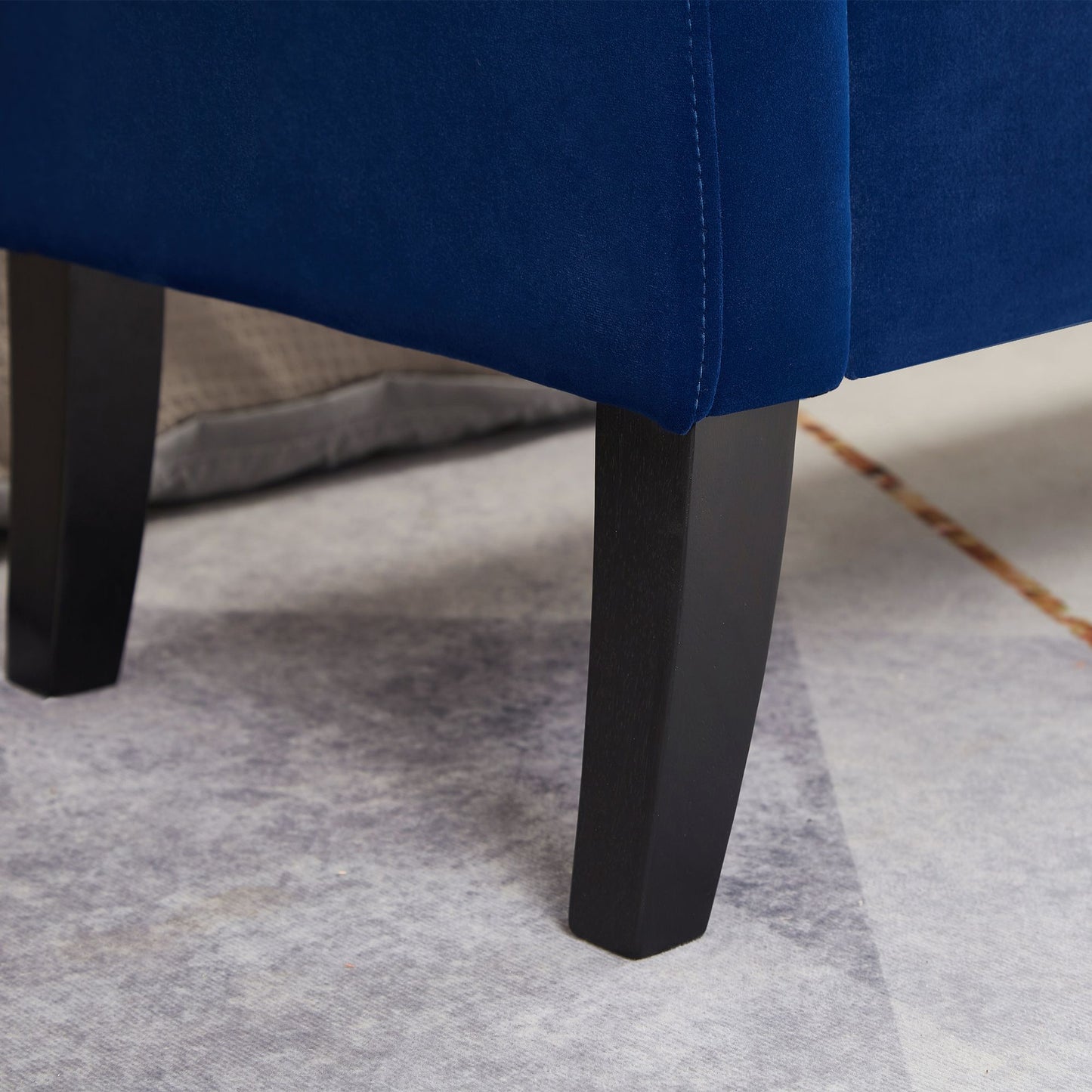 Navy blue tufted storage bench used as bed bench at foot of bed