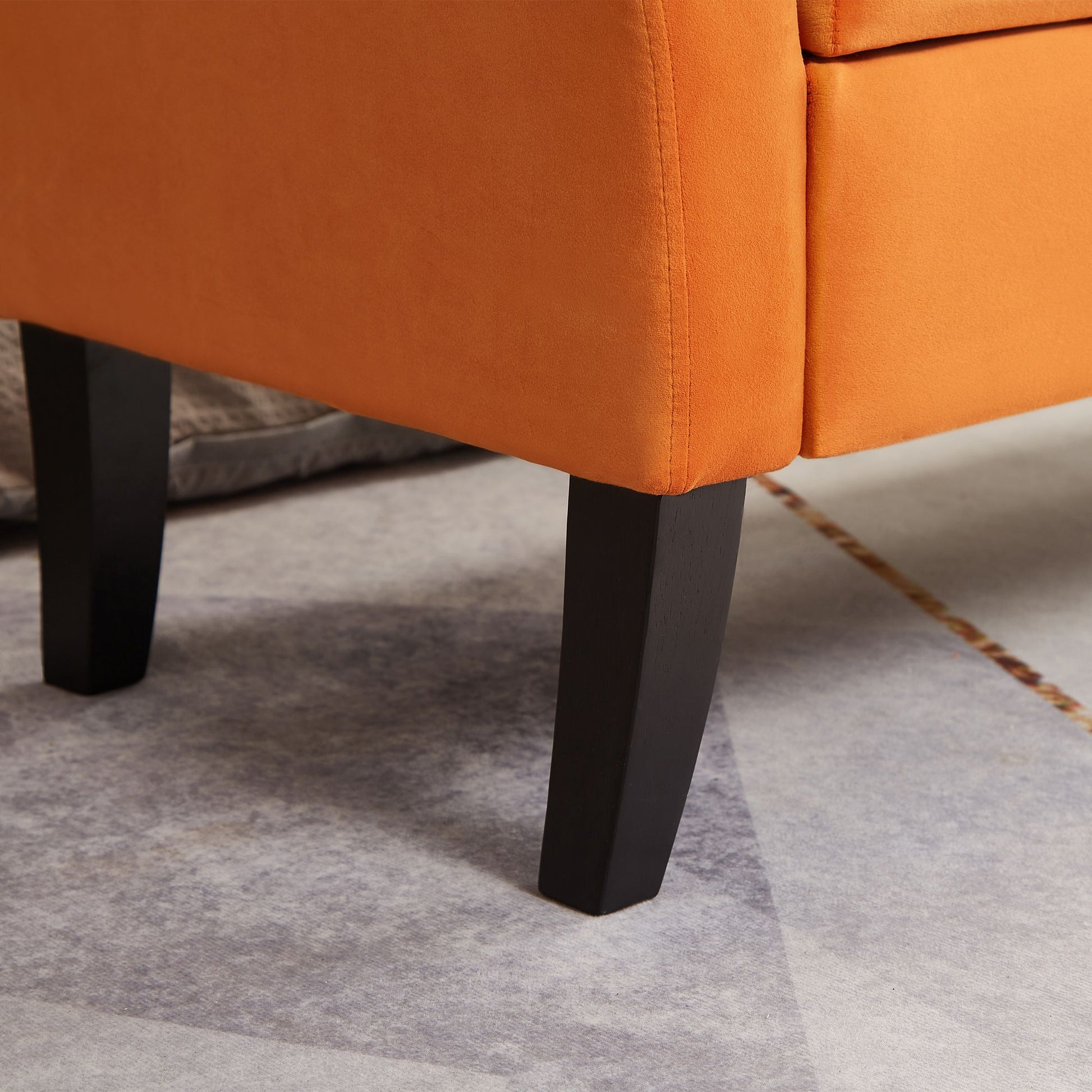 Orange velvet bench used as ottoman in living room setting