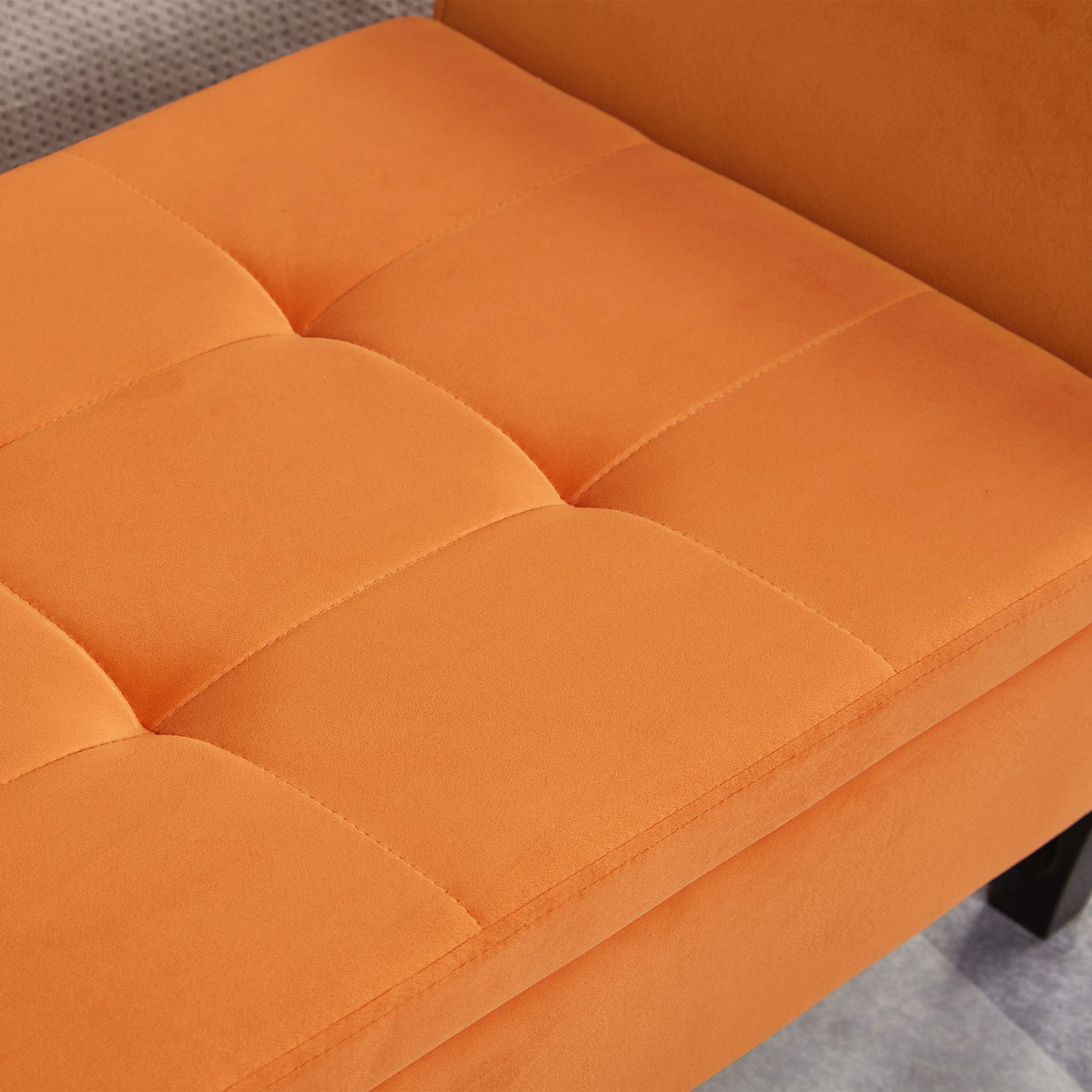 Storage bench with orange velvet upholstery and tufted seat detail