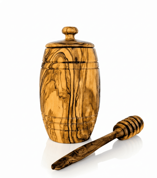 Olive wood honey pot with wooden dipper set on kitchen counter
